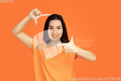 Image of Caucasian young woman\'s portrait on orange background