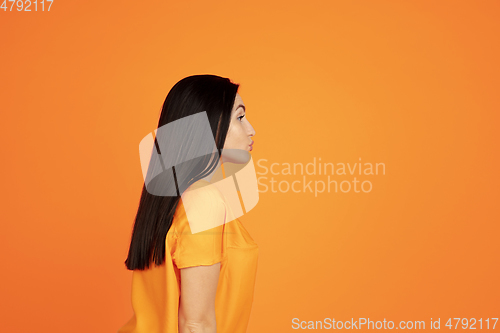 Image of Caucasian young woman\'s portrait on orange background