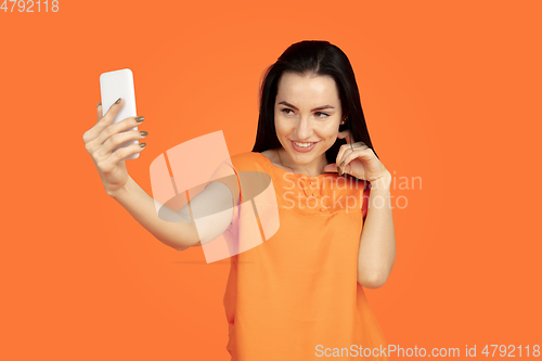 Image of Caucasian young woman\'s portrait on orange background