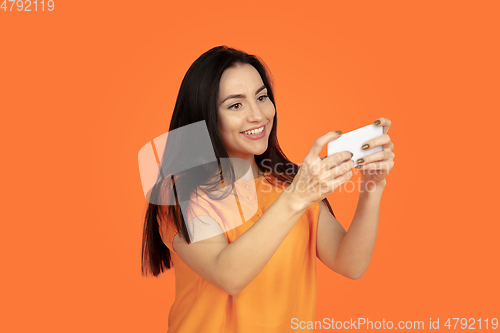 Image of Caucasian young woman\'s portrait on orange background