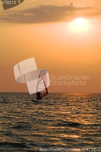Image of Silhouette of a windsurfer on a gulf on a sunset