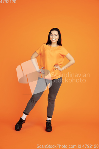 Image of Caucasian young woman\'s portrait on orange background