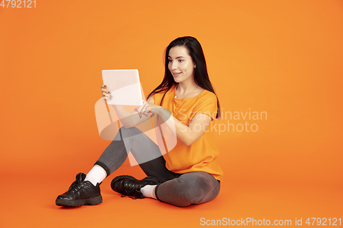 Image of Caucasian young woman\'s portrait on orange background