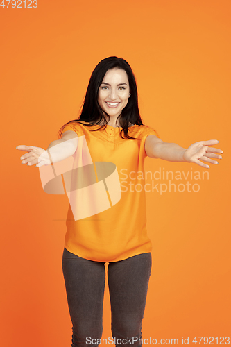 Image of Caucasian young woman\'s portrait on orange background