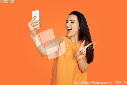Image of Caucasian young woman\'s portrait on orange background