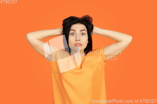 Image of Caucasian young woman\'s portrait on orange background