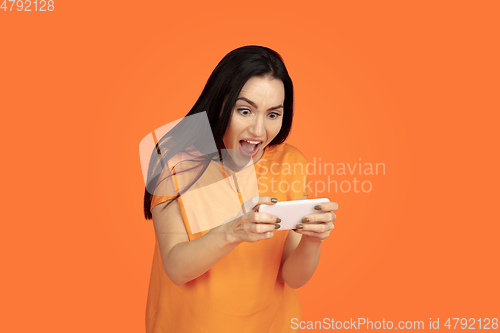 Image of Caucasian young woman\'s portrait on orange background