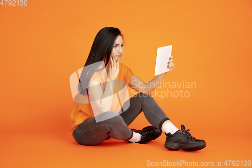 Image of Caucasian young woman\'s portrait on orange background