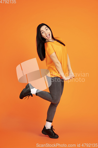 Image of Caucasian young woman\'s portrait on orange background