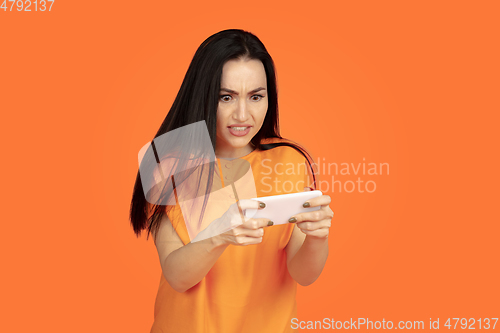 Image of Caucasian young woman\'s portrait on orange background