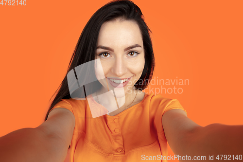 Image of Caucasian young woman\'s portrait on orange background