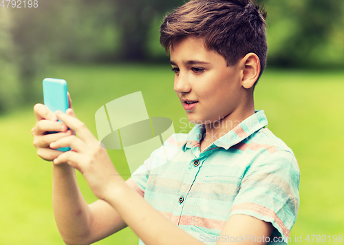 Image of boy with smartphone playing game in summer park