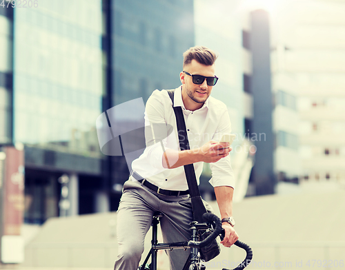 Image of man with bicycle and smartphone on city street