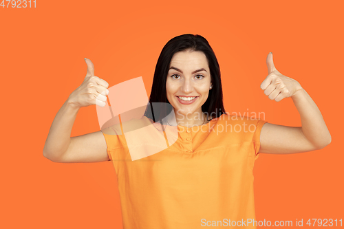 Image of Caucasian young woman\'s portrait on orange background