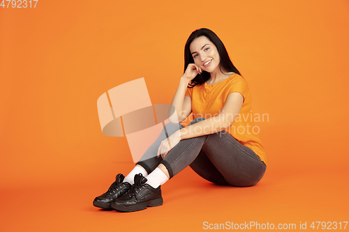 Image of Caucasian young woman\'s portrait on orange background