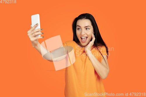Image of Caucasian young woman\'s portrait on orange background