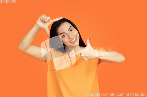 Image of Caucasian young woman\'s portrait on orange background