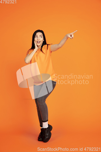 Image of Caucasian young woman\'s portrait on orange background