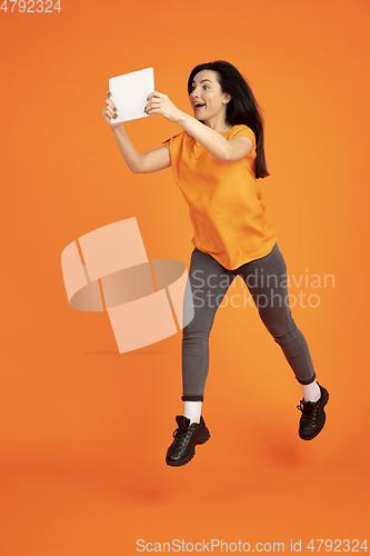 Image of Caucasian young woman\'s portrait on orange background