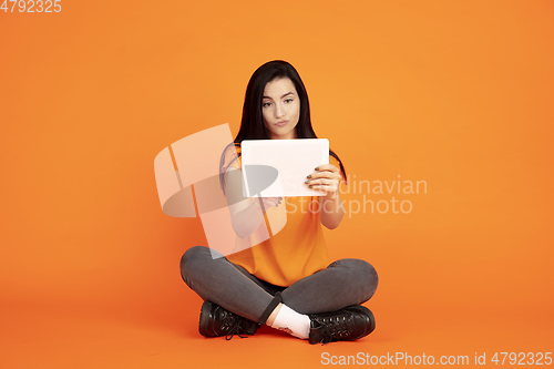 Image of Caucasian young woman\'s portrait on orange background