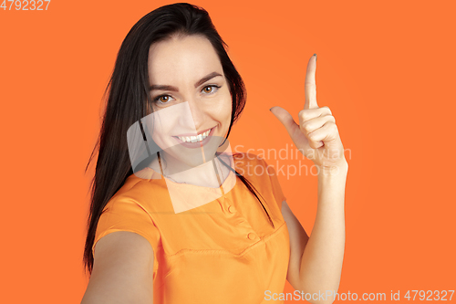 Image of Caucasian young woman\'s portrait on orange background