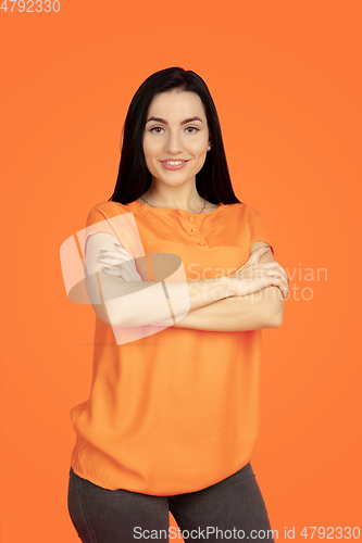 Image of Caucasian young woman\'s portrait on orange background