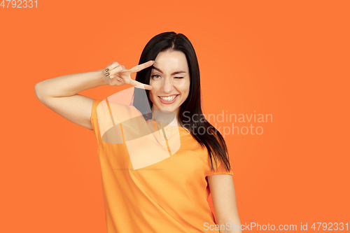 Image of Caucasian young woman\'s portrait on orange background