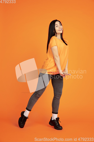 Image of Caucasian young woman\'s portrait on orange background