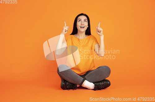 Image of Caucasian young woman\'s portrait on orange background