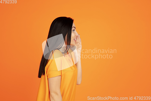 Image of Caucasian young woman\'s portrait on orange background