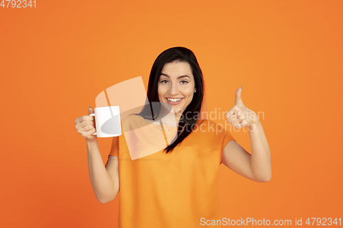 Image of Caucasian young woman\'s portrait on orange background