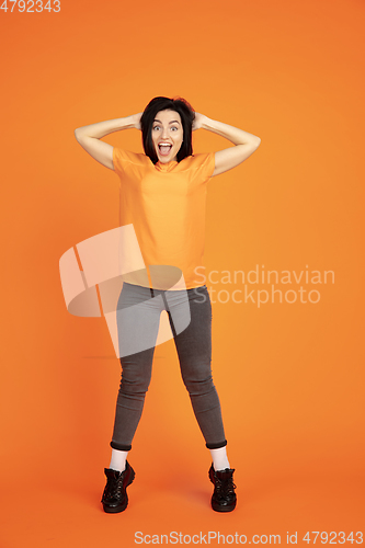 Image of Caucasian young woman\'s portrait on orange background