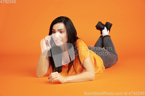 Image of Caucasian young woman\'s portrait on orange background