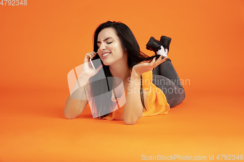 Image of Caucasian young woman\'s portrait on orange background