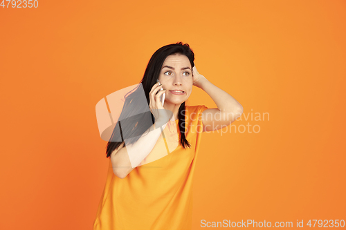 Image of Caucasian young woman\'s portrait on orange background