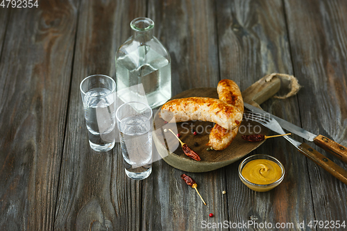 Image of Vodka and traditional snack on wooden background