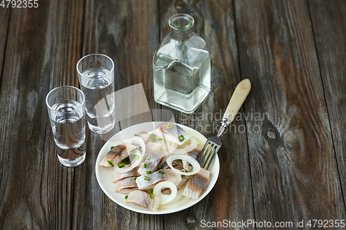 Image of Vodka and traditional snack on wooden background