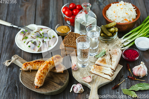 Image of Vodka and traditional snack on wooden background