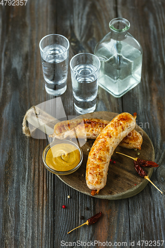 Image of Vodka and traditional snack on wooden background