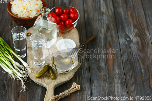 Image of Vodka and traditional snack on wooden background