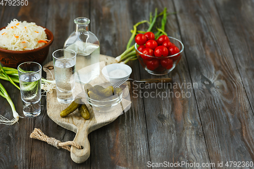 Image of Vodka and traditional snack on wooden background