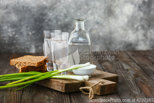 Image of Vodka and traditional snack on wooden background