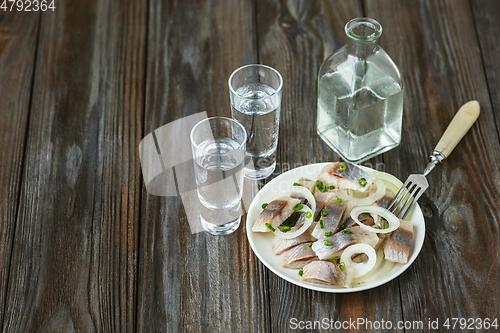 Image of Vodka and traditional snack on wooden background