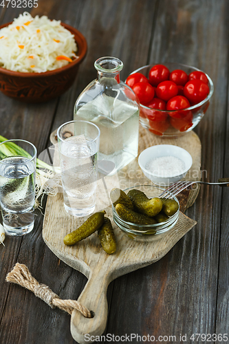 Image of Vodka and traditional snack on wooden background