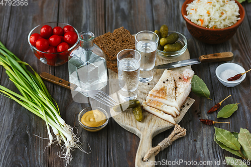 Image of Vodka and traditional snack on wooden background