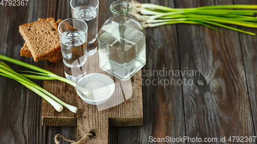 Image of Vodka and traditional snack on wooden background