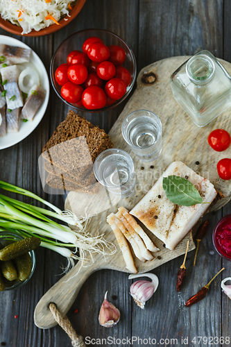 Image of Vodka and traditional snack on wooden background