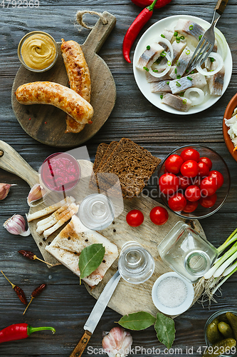 Image of Vodka and traditional snack on wooden background