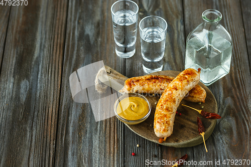 Image of Vodka and traditional snack on wooden background