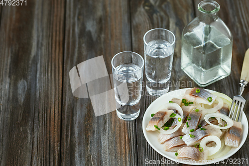 Image of Vodka and traditional snack on wooden background